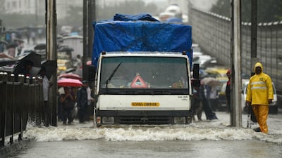 Vehicles drive through a flooded street during heavy rain showers in Mumbai on August 29, 2017. Heavy rain brought India's financial capital Mumbai to a virtual standstill on August 29, flooding streets, causing transport chaos and prompting warnings to stay indoors. Dozens of flights and local train services were cancelled as rains lashed the coastal city of nearly 20 million people. Punit Paranjpe / AFP