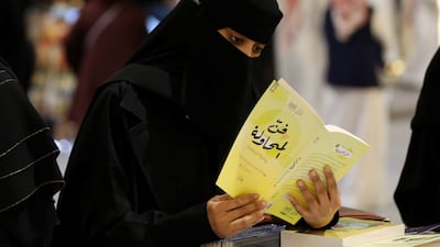 A Saudi woman reads during the Riyadh International Book Fair.