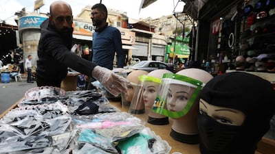 A seller displays face masks and face shields for customers in front of his shop in downtown Amman, Jordan. Reuters