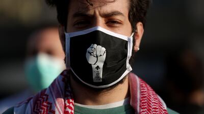 A Lebanese protester, wearing a protective mask bearing a fist, is pictured during a demonstration in the capital Beirut on April 28, 2020. AFP