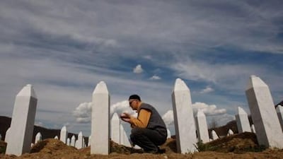 A Bosnian Muslim man says a prayer in front of the grave stone of his relative at Memorial Center of Potocari, near Srebrenica.