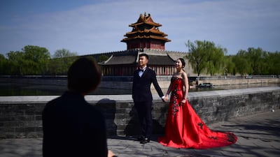 A couple poses for wedding photos near the Forbidden City in Beijing. Wang Zhao / AFP Photo