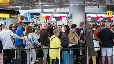 Travellers queue at Amsterdam Airport Schiphol, where staff shortages have led to passengers missing flights. AFP