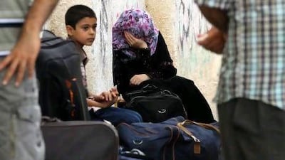 Palestinian families wait to enter into Egypt at the Rafah border crossing in the southern Gaza Strip.