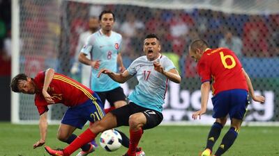 Andres Iniesta and David Silva of Spain tackle Burak Yilmaz of Turkey. Lars Baron / Getty Images