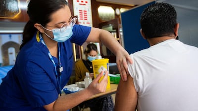 Hafsa, one of the medical volunteers, administers a vaccine at London Central Mosque. Mark Chilvers for The National