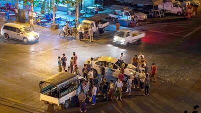 People gather around two vehicles involved in a traffic accident in Yangon in April. According to the government, just 5 per cent of the country's 600,000 drivers have any sort of insurance. Romeo Gacad / AFP