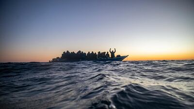 Migrants and refugees of different nationalities wait for assistance aboard an overcrowded wooden boat in the Mediterranean Sea. AP