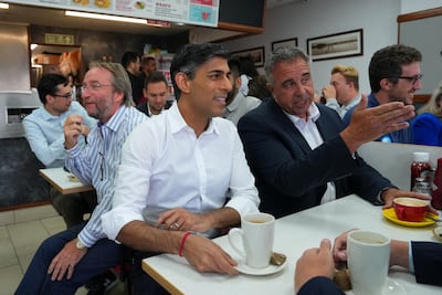 Rishi Sunak and Steve Tuckwell speak to locals in an Uxbridge cafe on Friday. Reuters