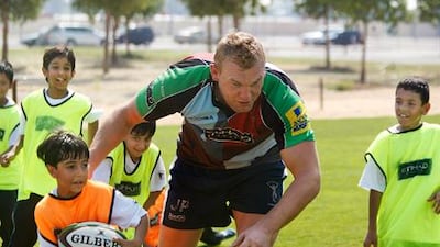 James Percival, London Harlequins lock, puts schoolchildren from the Emirates National School through their paces yesterday during a coaching session at Zayed Sports City.