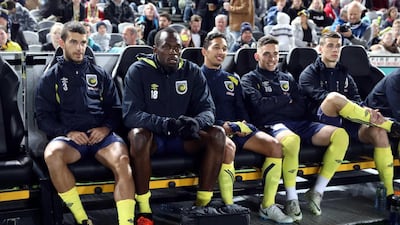 Usain Bolt sits on the bench ahead of his appearance for Central Coast Mariners during a pre-season friendly. AFP