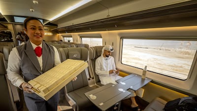 A staff member serves onboard an Etihad Rail train at Dubai's Yalayis station, during the inaugural passenger service connecting from Abu Dhabi's Mohamed Bin Zayed City station to Dubai. AFP