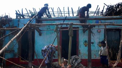 An Indian fisherman and family fix their house damaged during Cyclone Phailin in Jagannathpur village in Gopalpur. Asit Kumar / AFP Photo