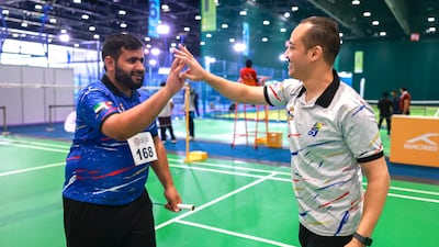 Emirati badminton player Majid Abdullah, left, celebrates a win with coach Ahmed Abdelrazek. Victor Besa / The National