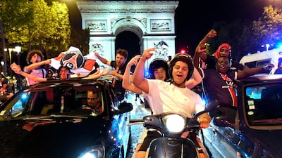 Paris Saint-Germain supporters wave the club flags as they celebrate on the Champs Elysee. AFP