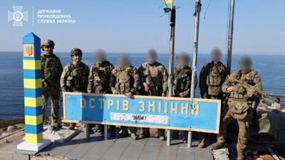 Ukrainian border guards stand next to a border sign on Snake Island in the Black Sea, in August. Reuters