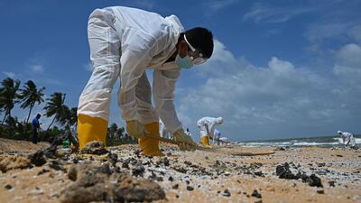 Members of Sri Lankan Navy remove debris washed ashore. AFP