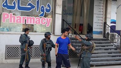 Afghan security forces stop a man near the site of an attack in Kabul AP