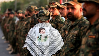 A member of Iraq's Popular Mobilisation Forces wears a Keffiyeh with a portrait of Iran's slain supreme leader Ali Khamenei ahead of security checks at the shrine of Imam Hussein on the eve of his funeral ceremonies. AFP
