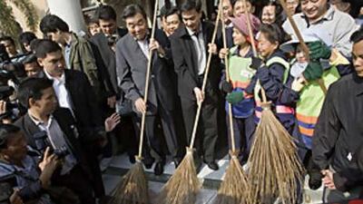 Thailand's Prime Minister Abhisit Vejjajiva, centre, along with caretaker prime minister Chawarat Chandeerakul, centre left, participate in a staged clean-up of Government House on Dec 19, 2008, in Bangkok, Thailand.