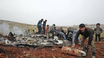 People search for scraps of metal among the debris of a Syrian military helicopter that was shot down in the western countryside of Aleppo province. AFP