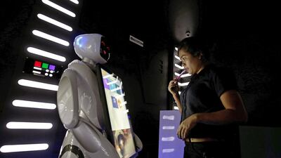 A woman books a table with a robot. EPA