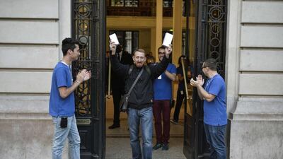 The first French customer to buy the latest iPhone holds two boxes containing the iPhone6, as he exits the Apple Store in Paris. Fred Dufour / AFP Photo