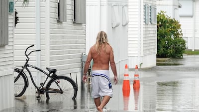 A resident walks through flooding caused by the rain bands of Hurricane Nicole in Briny Breezes, Florida. AP