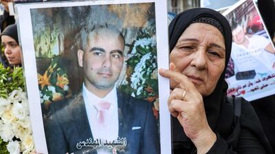 A family member of one of the victims holds up a portrait. AFP