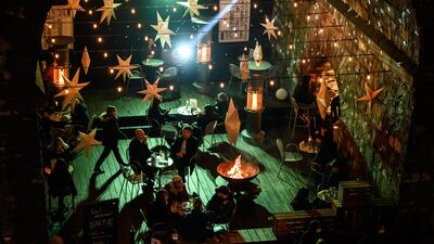 People drink in a bar located under the arches of a bridge, downtown Lausanne Switzerland, which is failing to control the Covid-19 epidemic with the highest contamination rates in Europe, is awaiting new lockdowns decisions after a meeting of Swiss government. AFP