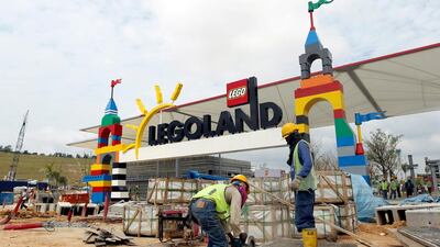 Labourers work in front of the entrance gates of the Legoland Malaysia theme park in 2012. A similar project in the UAE, Legoland Dubai, is slated to open in 2016. Stephen Morrison / EPA
