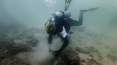 Volunteer diver Lee Becker collects trash from the murky ocean floor of the Abu Dhabi Free Port as part of the ‘Dive Together To Protect Our Marine Environment’ initiative. Antonie Robertson / The National