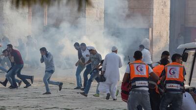 Palestinian worshippers run for cover during clashes with Israeli riot police at the Al-Aqsa Mosque compound. EPA/Fayiz Abu Rmeleh