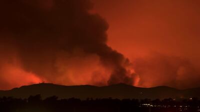 A wildfire burns on the hills of Ventura County as night falls and the winds calm near Ventura, California. Mike Blake / Reuters