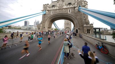 Runners cross Tower Bridge in London during a half marathon. PA