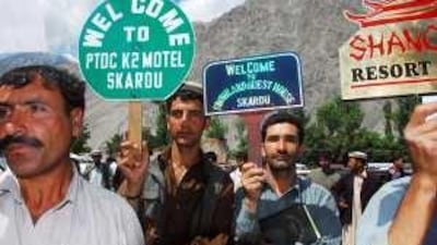 Hotel workers wait for arrivals at Skardu airport in Pakistan's Northern Areas.