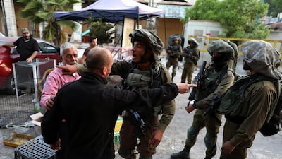Israeli soldiers on patrol stop Palestinians in the Old City of the West Bank town of Hebron. EPA