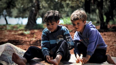 Esara'a son, Jamal and Bara ten and eleven years old sitting on a blanket playing together with a glass ball.