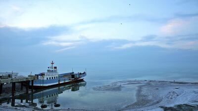 An abandoned ship sits stuck in a dock on the lake.