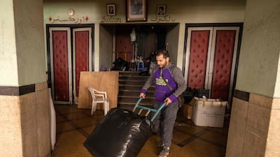 A man carries a bag of merchandise at the entrance of the "Al Malaki" cinema, located in the heart of the market in the working-class neighbourhood of Derb Sultan, in the western Moroccan city of Casablanca, on January 24, 2022. - During the coronavirus pandemic, cinemas across Morocco were closed for over a year before reopening in July 2021. But despite nine million dirhams (850,000 euros) of funding for the Moroccan Centre for Cinematography (CCM), which promotes and regulates film, the industry is struggling to extract itself from the crisis. (Photo by FADEL SENNA / AFP)