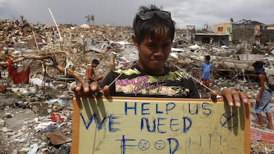 A typhoon victim asks for food while standing amongst the ruins of houses destroyed by super typhoon Haiyan in Tanauan, Leyte. Erik De Castro / Reuters