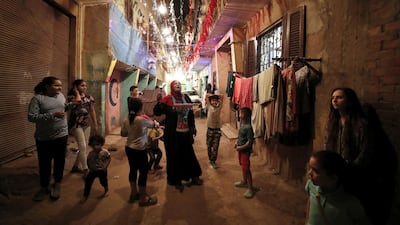 An Egyptian 'Mosahrati', or late night waker, bangs her drums and calls out to the Muslim faithful around the Maadi neighbourhood before dawn in Cairo, Egypt. EPA