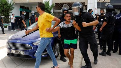 Police officers detain a demonstrator at the protest.