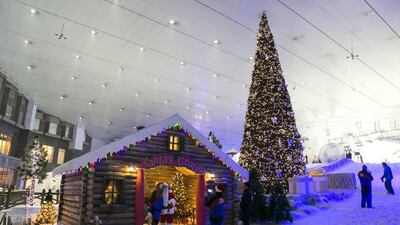 Santa takes a photo with a girl outside his grotto within Ski Dubai. Reem Mohammed / The National
