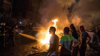 People extinguish a fire from a blast outside the National Cancer Institute, Cairo, Egypt. EPA