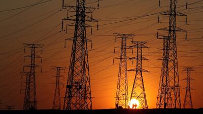 Locals walk past Eskom's electricity pylons as they return from work in Orlando, Soweto township. The utility's inability to supply sufficient electricity has curbed economic growth, with Goldman Sachs describing it as the greatest threat to South Africa's economy. Reuters