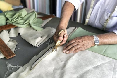 Mohammed Imtiaz cuts fabric at his shop. Reem Mohammed / The National