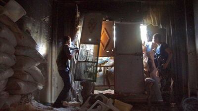 A Free Syrian Army fighter smokes a cigarette as he takes cover inside a house with a fellow fighter in Deir al-Zor. Khalil Ashawi / Reuters