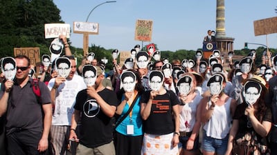 Protesters against the National Security Agency’s PRISM surveillance programme wear masks of US whistleblowers Edward Snowden and Bradley Manning, in June 2013 in Berlin, after US president Barack Obama defended the programme on his visit. Chad Buchanan / Getty Images
