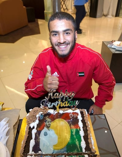 Hamad Nawad, gold medallist in the 56kg division, celebrates his birthday with a cake given to him by his mother at the airport. Leslie Pableo / The National